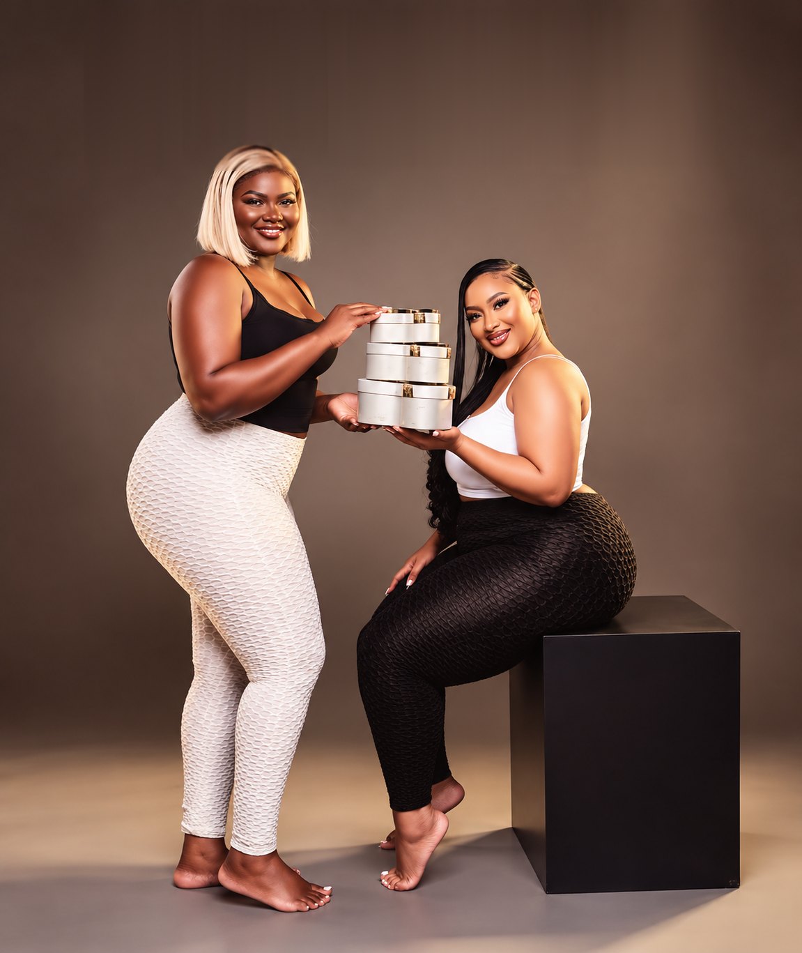 Deux femmes en studio, tenant les boîtes rondes Empire Ye